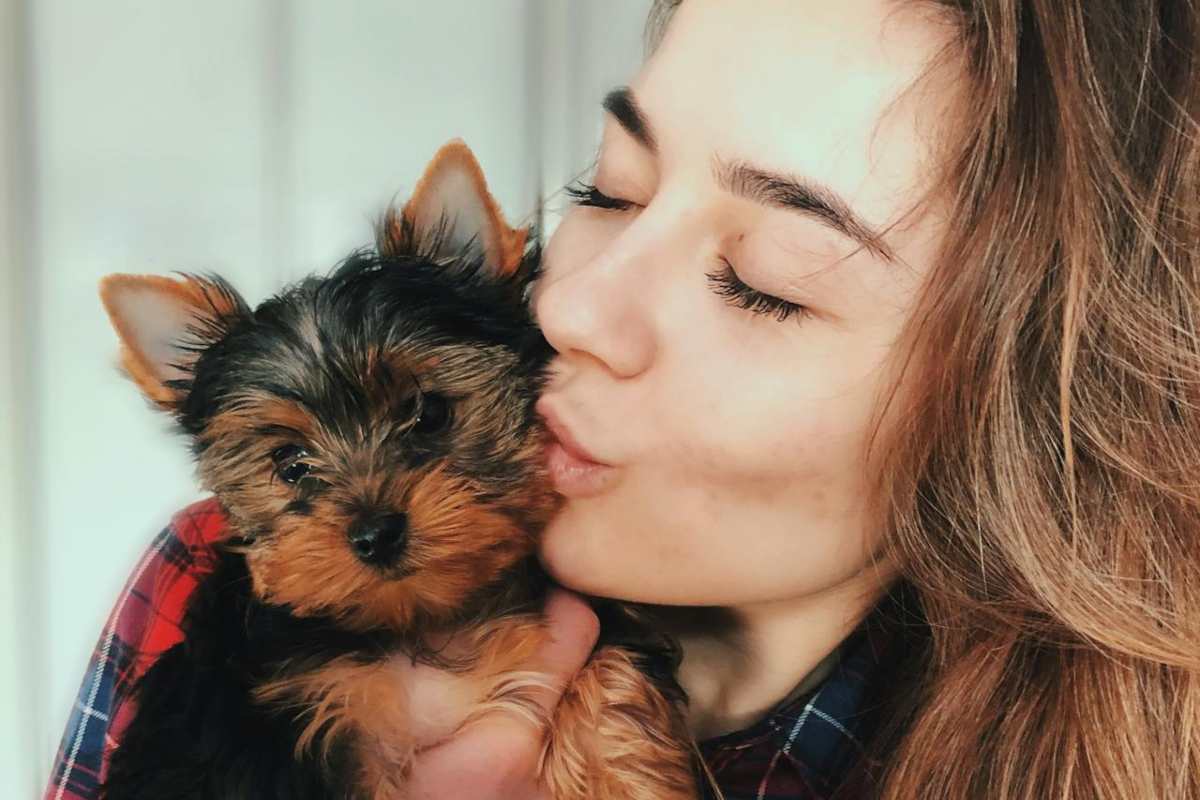 Ragazza che bacia un cagnolino